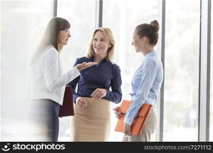 Businesswomen planning strategy against window at office during meeting