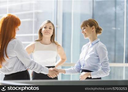 Businesswomen shaking hands in office