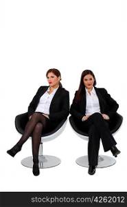 Businesswomen sitting side by side