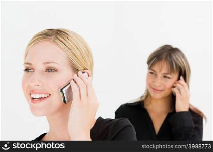 Businesswomen using cell phones