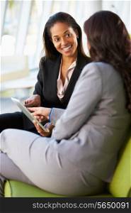 Businesswomen With Digital Tablet Sitting In Modern Office