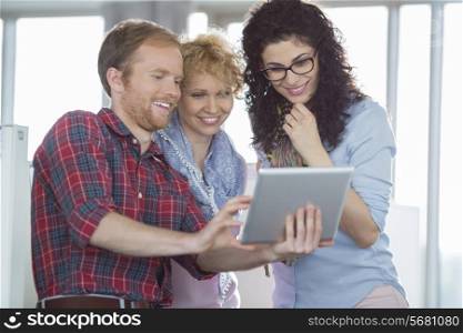 Businesswomen with male colleague using tablet PC in creative office