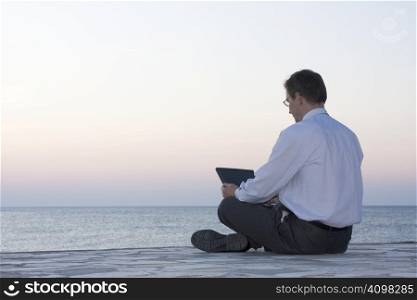 Businsessman working with laptop by the sea
