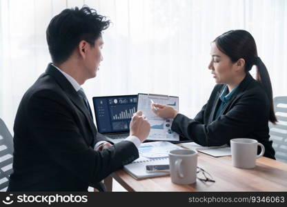 Busy analyst team in office discuss data analysis and marketing strategy using BI dashboard and statistics on laptop screen to improve business performance at meeting with strong teamwork. Jubilant. Busy analyst team in office discuss data analysis and marketing. Jubilant