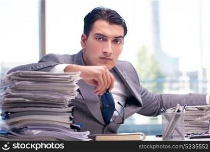 Busy angry businessman with heaps of paper