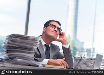 Busy angry businessman with heaps of paper. The busy angry businessman with heaps of paper