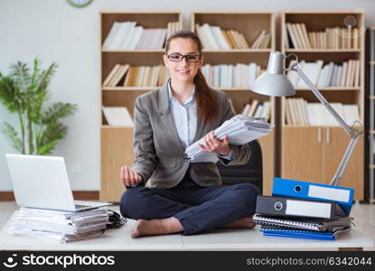 Busy angry businesswoman sitting on the desk in office