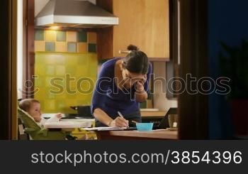 Busy businesswoman with telephone, multitasking mother cooking and working, feeding baby girl at home