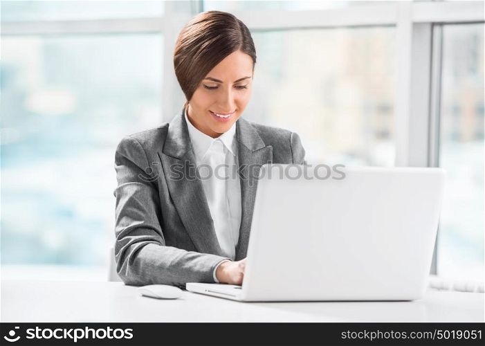 Busy caucasian business woman using laptop at office desk