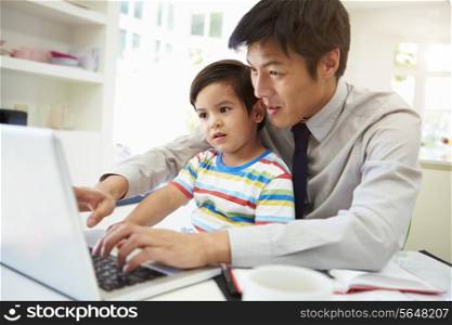 Busy Father Working From Home With Son