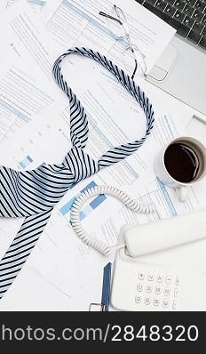 Busy office desk tie lying on paper charts business meeting