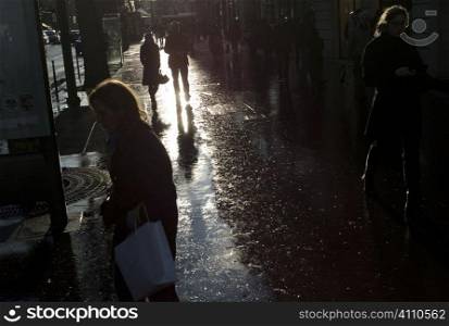 Busy shopping street in winter sunlight after rain, Paris, St Germain