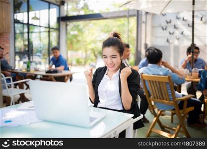 Busy young business woman working on desk using laptop in coffee shop , look of success