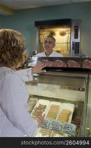 Butcher attending to customer