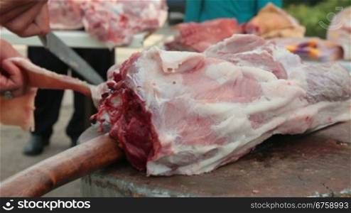 Butcher cutting fresh pork meat