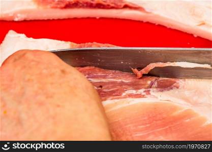 Butcher cutting little pieces of fat pork meat