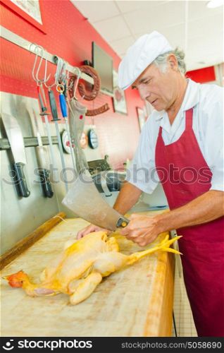 Butcher jointing a chicken