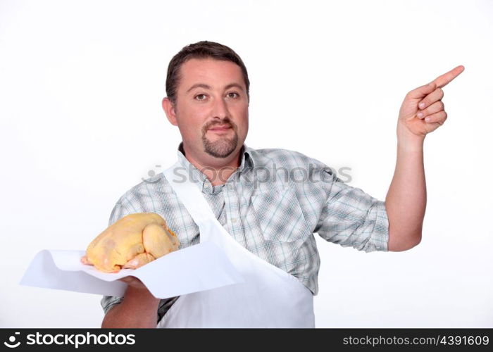 Butcher pointing with a chicken