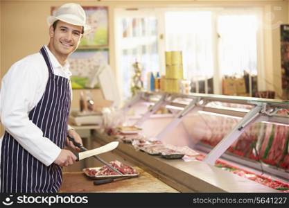 Butcher Preparing Meat In Shop