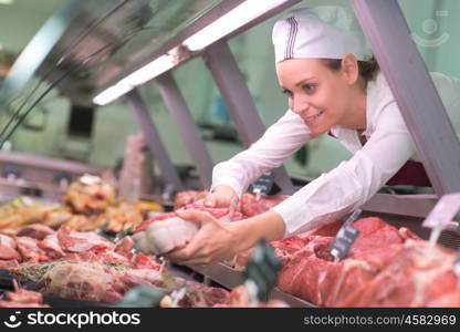 Butcher reaching meat out of counter