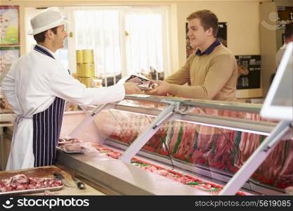 Butcher Serving Customer In Shop