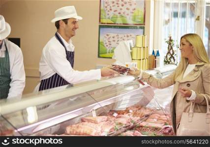 Butcher Serving Customer In Shop