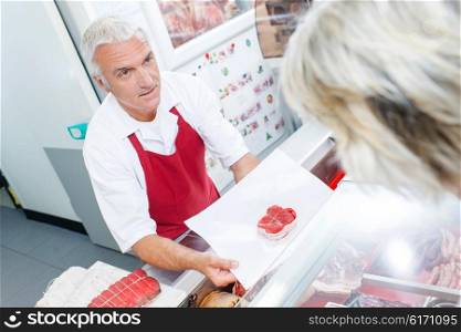 Butcher serving one of his customers
