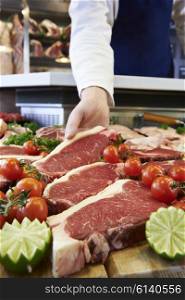 Butcher Showing Customer Sirloin Steak In Refrigerated Display