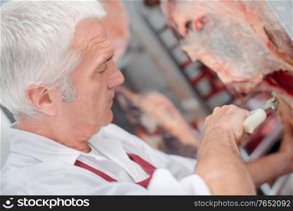 Butcher slicing piece of meat