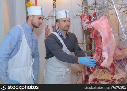 butcher teaching young trainee