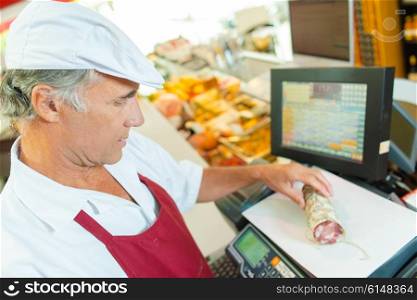 Butcher weighing cured meat