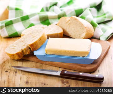 butter with bread on wooden board