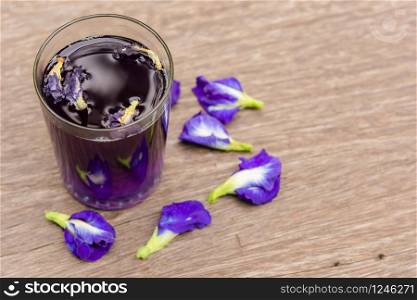 Butterfly pea juice and butterfly pea flower on wood background