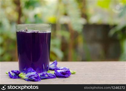 Butterfly pea juice and butterfly pea flower on wood background
