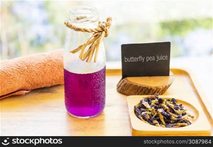 Butterfly pea juice is placed in a wooden tray with dried butterfly pea flowers. Thai herbs for health
