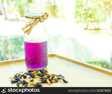 Butterfly pea juice is placed in a wooden tray with dried butterfly pea flowers. Thai herbs for health