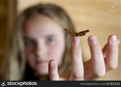 Butterfly perching on fingertip of a girl, Lake of The Woods, Ontario, Canada