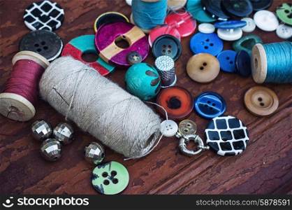 Buttons and thread. set of threads and buttons on old wooden background