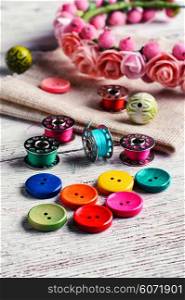 Buttons of different colors and accessories for needlework. Bright buttons and thread