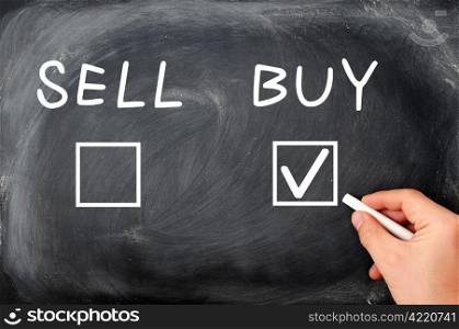 Buy or sell check boxes on a blackboard. Finance, economy, stock or real estate concept - time to buy.