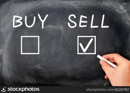 Buy or sell check boxes on a blackboard. Finance, economy, stock or real estate concept - time to sell.