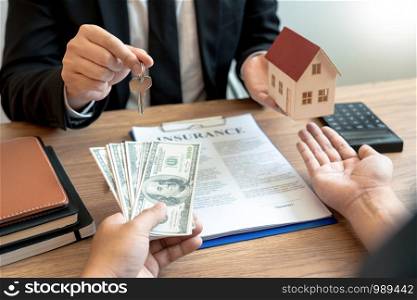buy or sell real estate concept, Sale representative offer house purchase contract to buy a house or apartment and give home key chain to customer