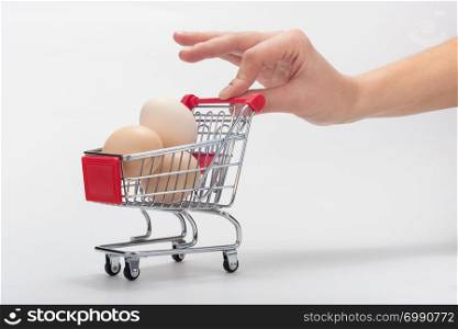 Buyer pushes miniature grocery cart with chicken eggs