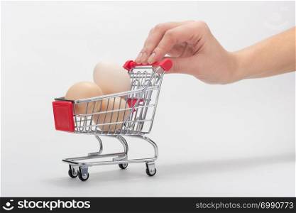 Buyer&rsquo;s hand carries a grocery cart with chicken eggs