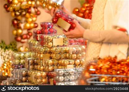 Buyer shopping shiny Christmas balls in plastic boxes
