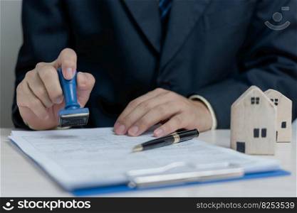 Buying and selling real estate or borrowing money, bank loans, approved investments.Businessman rubber stamp document on desk.