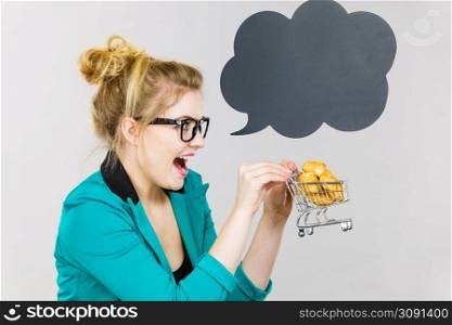 Buying gluten food products concept. Bussines woman holding shopping cart trolley with sweet bun, black thinking or speech bubble next to her.. Bussines woman holding shopping cart with sweet bun