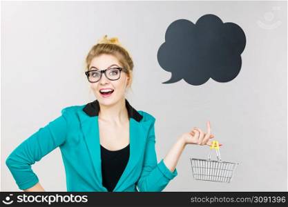 Buying things at market shops concept. Business woman hand holding small tiny shopping cart trolley. Business woman holding small tiny shopping cart