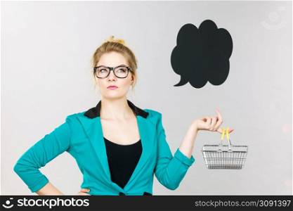 Buying things at market shops concept. Business woman hand holding small tiny shopping cart trolley. Business woman holding small tiny shopping cart