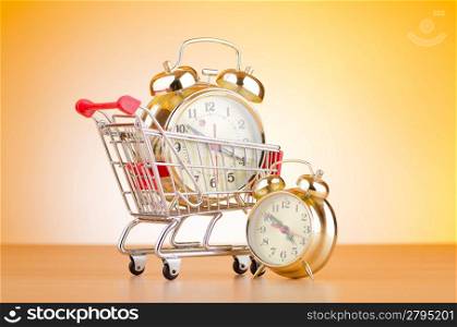 Buying time concept with clock and shopping cart